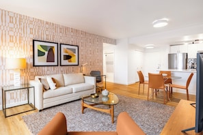 Un salon moderne avec un canapé, une table basse et des œuvres d’art accrochées au mur.