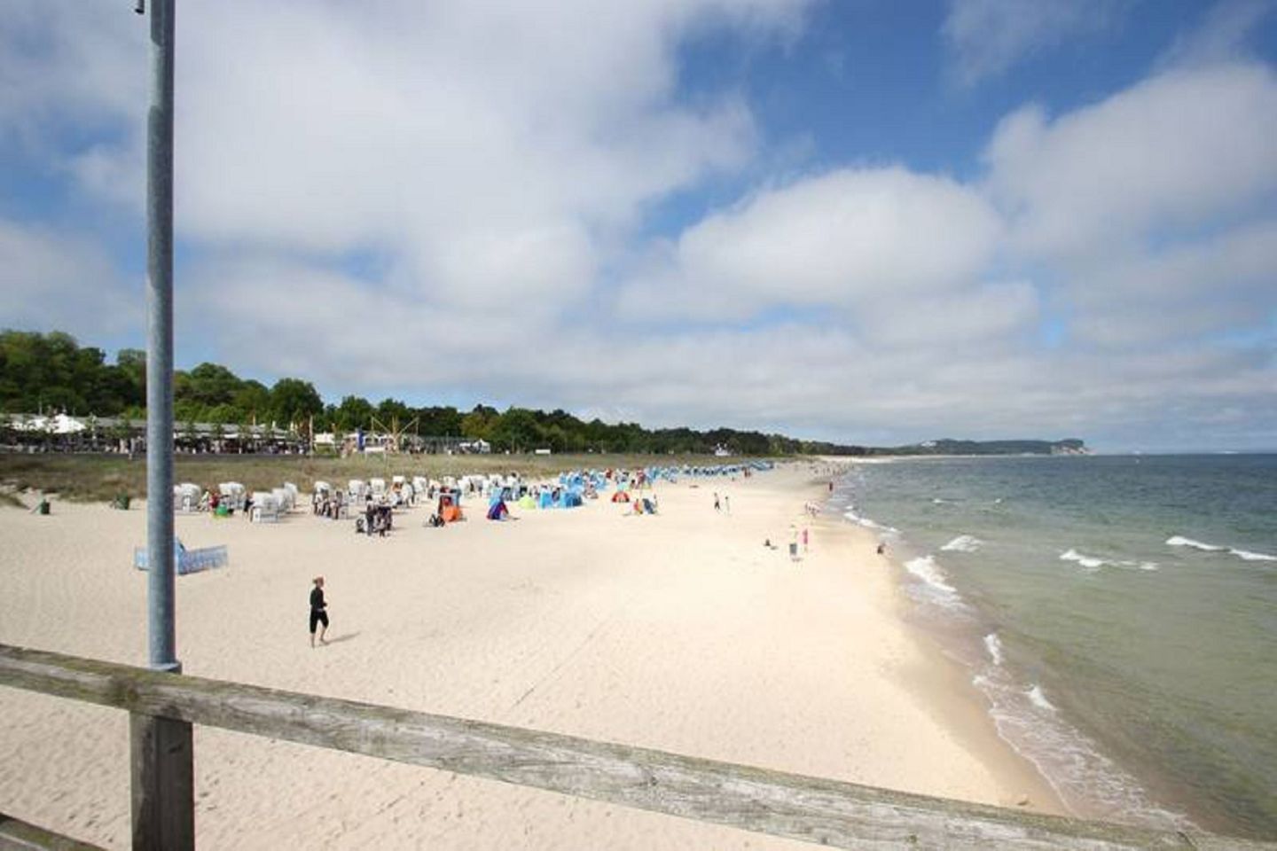 Een strand met een zandstrand, tenten en een heldere lucht.