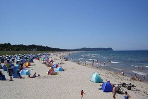 A beach with numerous colorful tents and people enjoying the seaside.