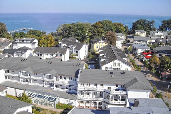 A coastal residential area with houses, a pier, and a view of the sea.