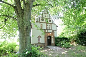 A church with a brick facade, arched windows, and a bell tower, surrounded by lush greenery. - Villa Hermine - fabulous villa in an idyllic location with sea views - Villa (Altefähr)