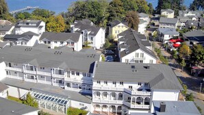A coastal residential area with multiple two-story houses, a pier, and a view of the sea. - Vacation apartment with balcony, use of swimming pool and sauna - Haus Strandeck FeWo 19 (Göhren)