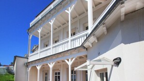 Um edifício branco com varanda e várias janelas.