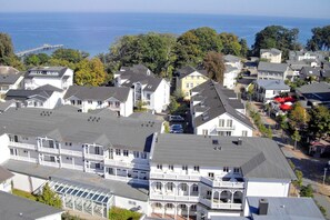 A coastal residential area with multiple two-story houses, a pier, and a view of the sea. - Die Ferienwohnung Nr. 20 im Haus Strandeck - Haus Strandeck (Göhren)