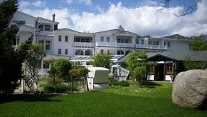 A multi-story building with a garden in front. - FeWo Ostseeperle - with sea view and balcony, use of swimming pool and sauna - FeWo (Göhren)