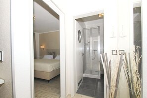 Habitació d'hotel amb llit, dutxa i bany petit.