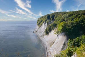 Paisagem costeira com um penhasco e uma praia.