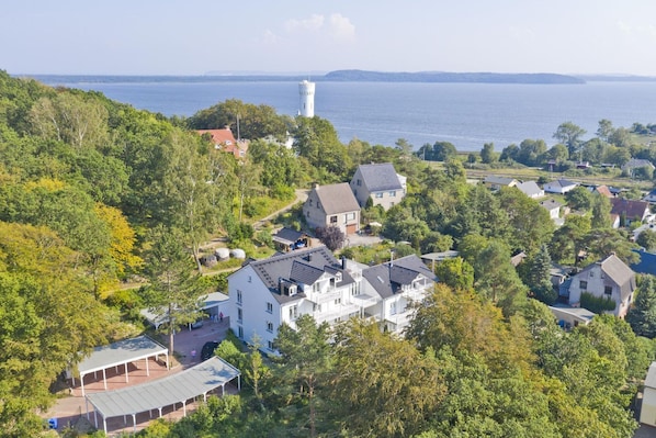 A residential area with houses, a tower, and a lake.