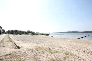 A sandy beach with a playground and a small shed.