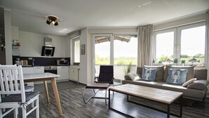 En moderne stue med sofa, sofabord og spiseplads.