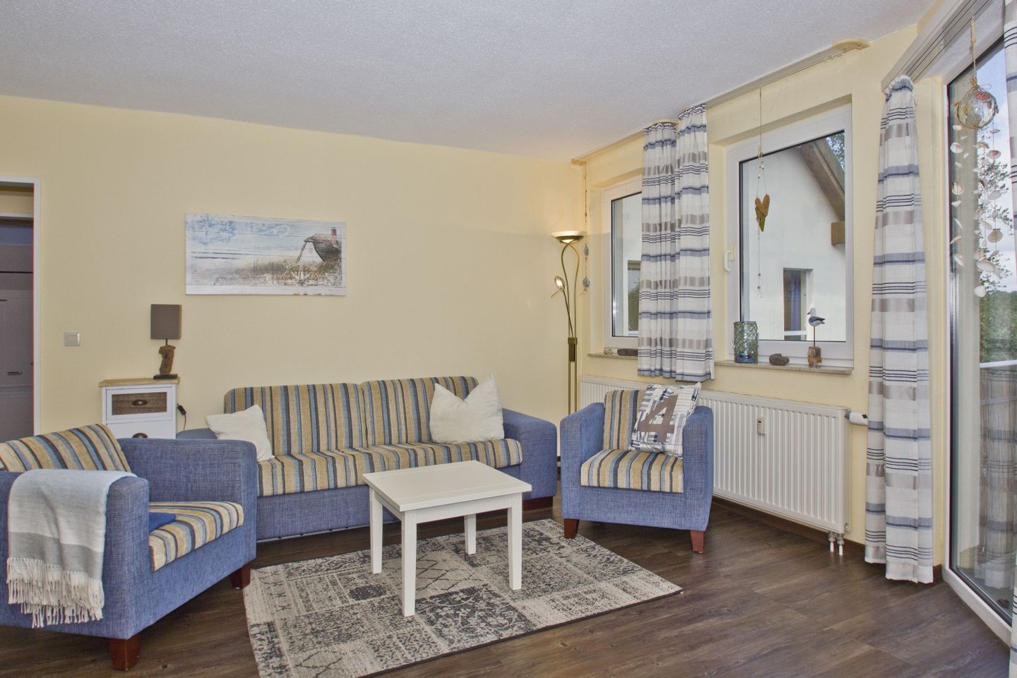 A living room with a sofa set, a coffee table, and a radiator.