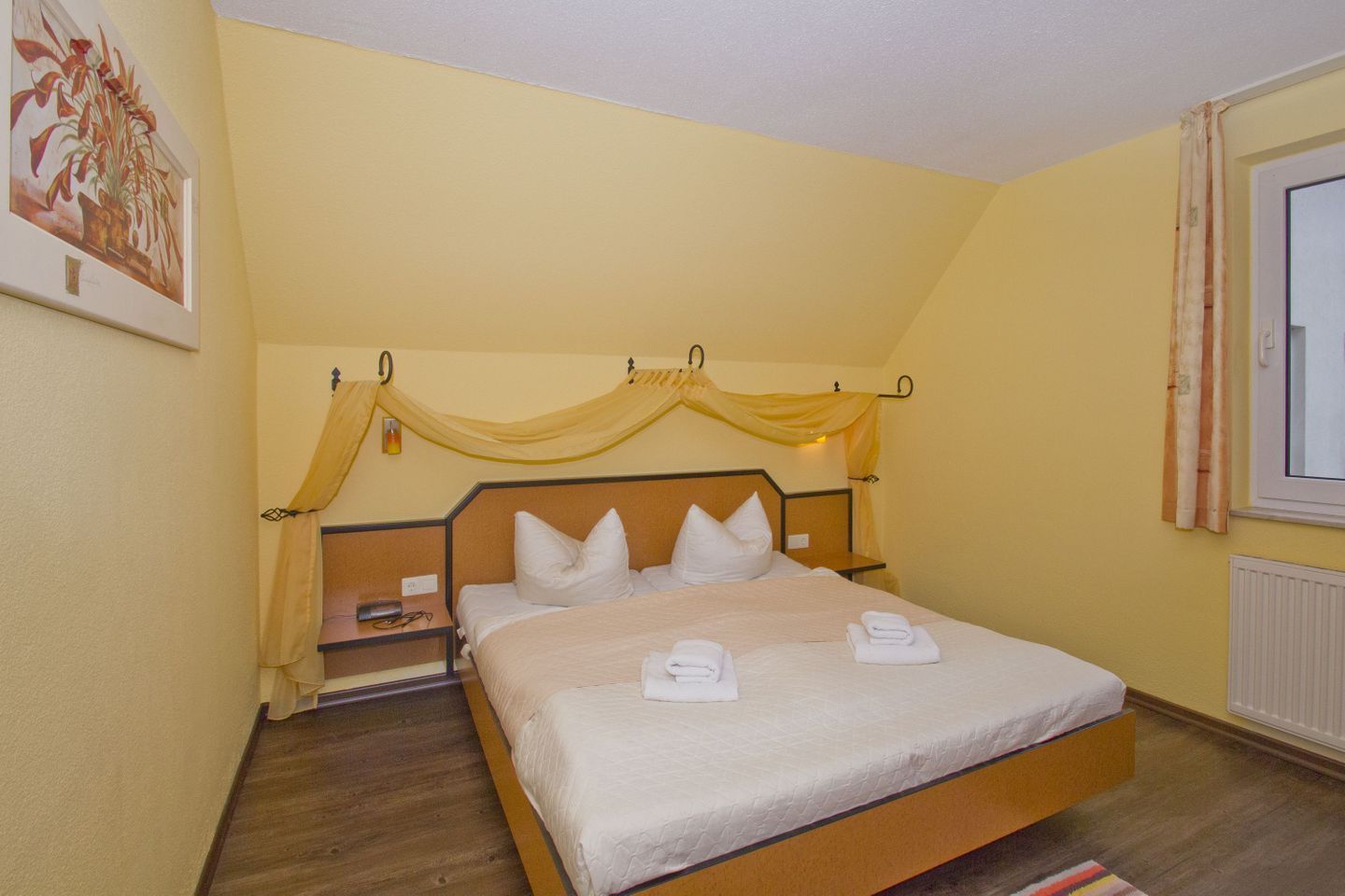 A single bed with a headboard, a bedside table, and a nightstand.