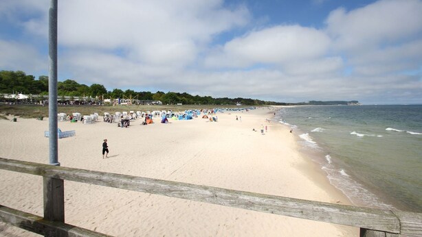 A beach with a wooden walkway, tents, and people. - Modern vacation apartment with private sauna and balcony - Villa Pauline FeWo 07 - (Göhren)
