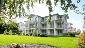 A multi-story hotel with a symmetrical facade, balconies, and a well-maintained lawn. - Modern vacation apartment with private sauna and balcony - Villa Pauline FeWo 07 - (Göhren)