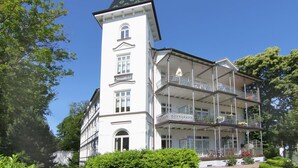 Ein weißes Gebäude mit einem Turm und mehreren Balkonen.