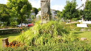 Ein Steins Denkmal, umgeben von üppiger Vegetation und einem gepflegten Garten.