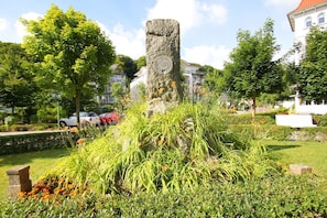 Ein Steins Denkmal, umgeben von üppiger Vegetation und einem gepflegten Garten.