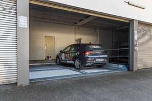 Un coche aparcado dentro de un garaje con la puerta cerrada.