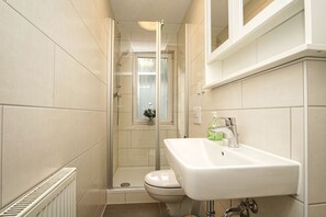 Ein kleines Badezimmer mit Dusche, Toilette und Waschbecken.