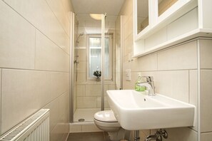 A compact bathroom with a shower, toilet, and sink. - Ferienhaus Inselhus - small vacation home with garden and terrace - Holiday home (Glowe)