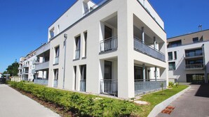 A modern multi-story residential building with balconies, a flat roof, and a clean, white exterior. - Dünenresort Binz - beachfront, chic vacation apartment with balcony directly in Binz - (Binz)