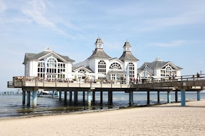 A pier with a white building featuring large windows and a central tower. - Villa Wauzi - Carpe Diem Vacation Apartment at Villa Wauzi in Baabe (Baabe)