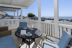 A balcony with a table and chairs, overlooking a coastal view. - With a view of the sea and a balcony; access to the pool and sauna - Sea View Apartment 28 - (Göhren)