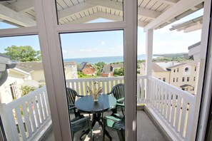 A balcony with a table and chairs, overlooking a residential area and the sea. - With a view of the sea and a balcony, access to the pool and sauna - Sea View Apartment 39 - (Göhren)