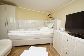 A compact bedroom with a bed, a TV, and a bedside table. - Vacation Apartment No. 58 in the Meeresblick Residences - Meeresblick (Göhren)