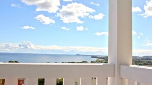 Un balcón con vista al mar y a la costa distante.