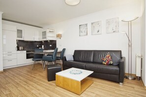 Una sala de estar moderna con un sofá, una mesa de centro y un comedor con sillas.