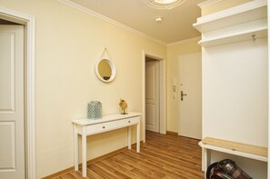 A hallway with a white console table, a mirror, and a door leading to another room. - With a view of the sea and a balcony; access to the pool and sauna - Apartment 38 with a view of the sea - (Göhren)