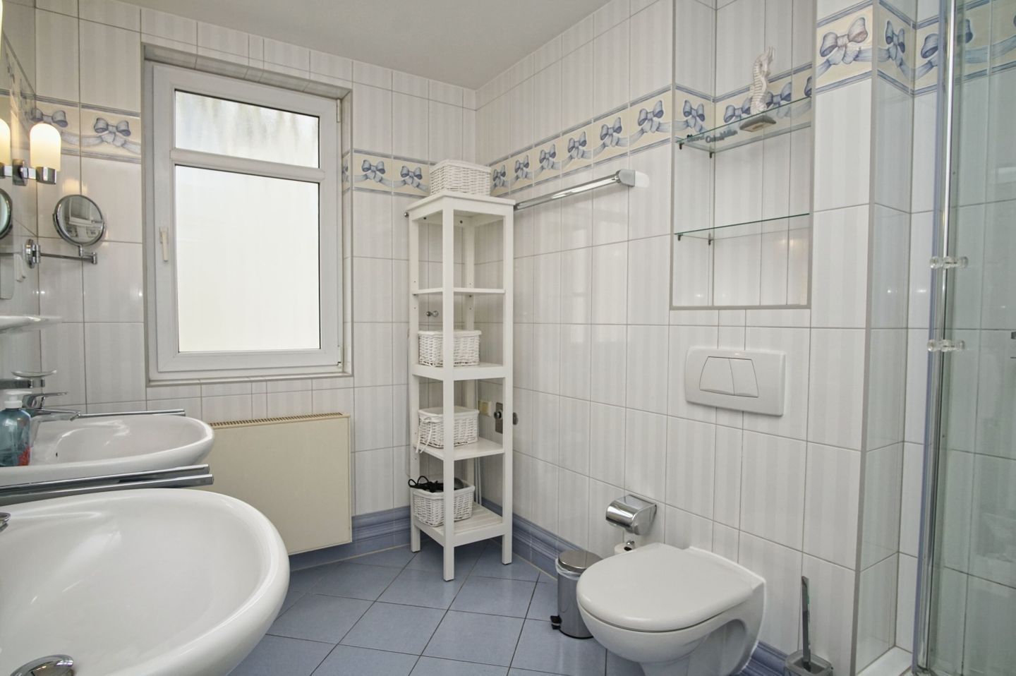 A bathroom with a toilet, sink, and shower.
