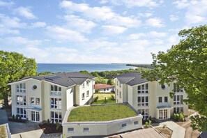 En modern byggnad med flera våningar, ett platt tak och utsikt över havet.