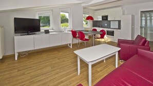 A modern living space with a kitchen, dining area, and seating area. - With sea view and balcony, use of swimming pool and sauna - Sea view apartment 18 - (Göhren)