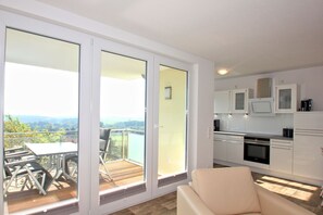 Un appartement moderne doté d’un balcon, d’un coin repas et d’une cuisine.