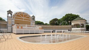 A public square with a fountain, seating areas, and a building with a dome and towers. - With sea view and terrace, use of swimming pool and sauna - sea view apartment 68 - (Göhren)