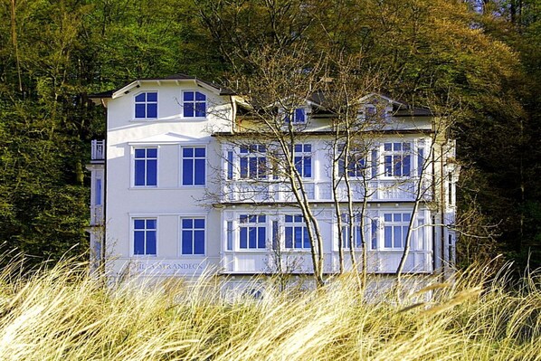 A multi-story building with a symmetrical facade, large windows, and a flat roof.