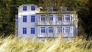 Un immeuble à plusieurs étages doté d’une façade symétrique, de grandes fenêtres et d’un toit plat.