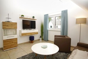 A modern living room with a TV, sofa, and coffee table.