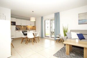 A modern apartment with a kitchen, dining area, and living room.
