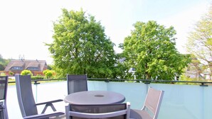 A balcony with a round table and two chairs, surrounded by a glass railing. - Beachfront vacation rental with a balcony, access to the pool and sauna - Rex Rugia H-1010 - (Göhren)
