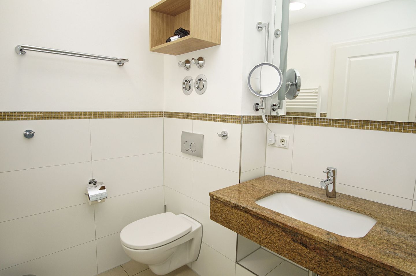 A bathroom with a toilet, a sink, a mirror, and a towel rack.