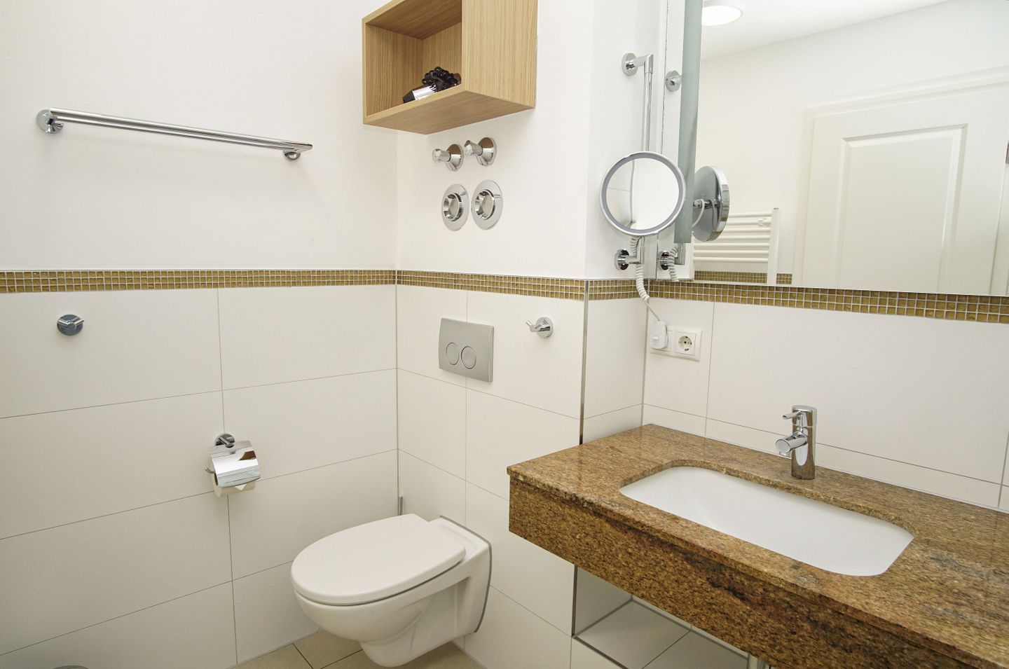 Ein Badezimmer mit Toilette, Waschbecken, Spiegel und Handtuchhalter.