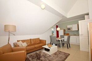 A modern apartment with a living room, dining area, and kitchenette. - Beachfront vacation rental with a balcony, access to the pool and sauna - Rex Rugia H-1010 - (Göhren)