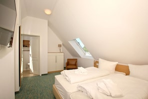 A hotel room with a bed, a desk, a chair, a wardrobe, and a skylight. - Beachfront vacation rental with a balcony, access to the pool and sauna - Rex Rugia - Rex Rugia (Göhren)