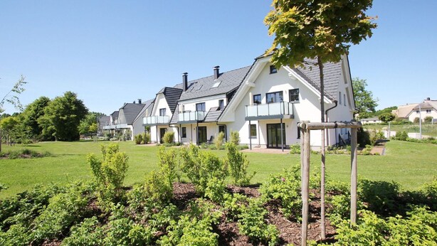 A row of modern houses with a well-maintained lawn and garden in front. - Beachfront vacation rental with a balcony, access to the pool and sauna - Rex Rugia - Rex Rugia (Göhren)