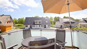 A balcony with a table and chairs, overlooking a residential area with houses. - Beachfront vacation rental with a balcony, access to the pool and sauna - Rex Rugia - Rex Rugia (Göhren)