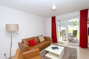 A modern living room with a brown leather sofa, a white coffee table, and a floor lamp.