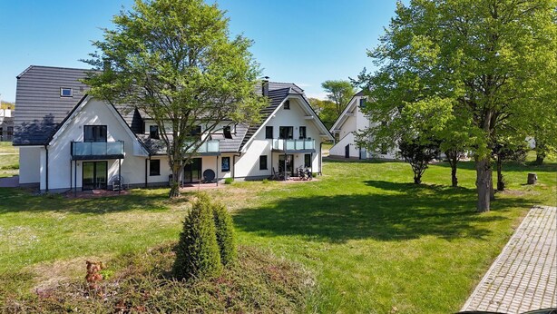 A modern residential building with a large lawn, a paved driveway, and a small garden area. - Beachfront vacation rental with a balcony, access to the pool and sauna - Rex Rugia - Rex Rugia (Göhren)